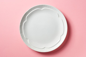 White plate on pink background, from above