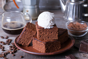 Chocolate cake with ice cream on plate on wood table.
