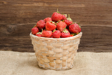 Basket of ripe strawberries on a sackcloth. Space for text