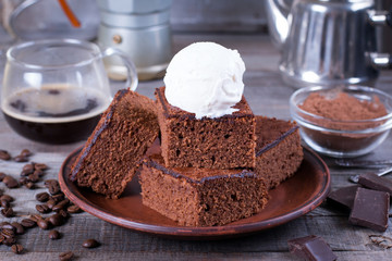 Chocolate cake with ice cream on plate on wood table.