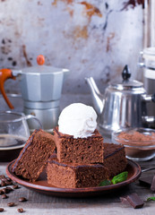 Chocolate cake with ice cream on plate on wood table.