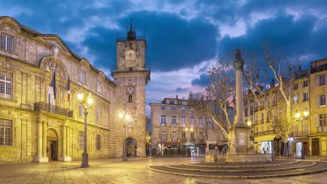 Town hall square at dusk with clock tower and fountain in Aix-en-Provence, France (static image with animated sky)