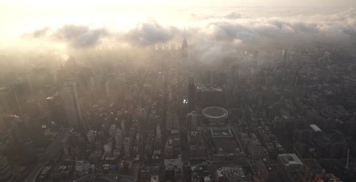 New York City aerial view of Midtown Manhattan from Hell's Kitchen with fog and low level clouds at sunrise.