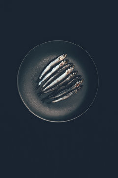 Top view of pile of fish in frying pan isolated on black