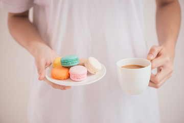 Fototapeta na wymiar Hands holding colorful pastel cake macarons or macaroons
