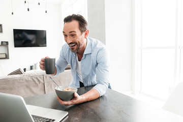 Excited mature man having healthy breakfast