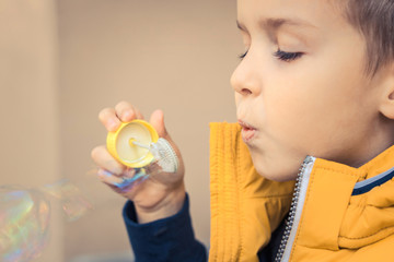 Close up of boy blowing bubbles.