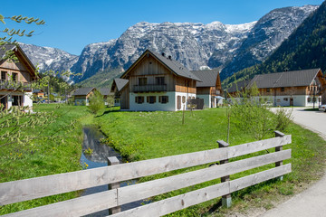 Several wooden huts on a green meadow