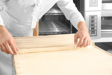 Man cooking delicious French bread in bakery