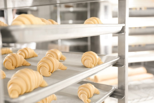 Trays With Uncooked Sweet Croissants In Bakery