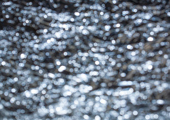 Sparkling spots of Bokeh - a water surface is not in focus, brilliant notes,  the background, metal, blue tint

