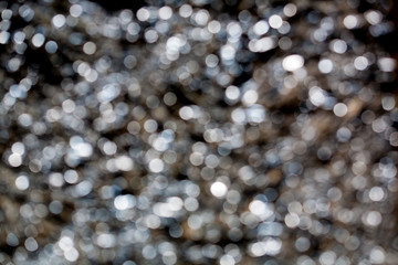 Sparkling spots of Bokeh - a water surface is not in focus, brilliant notes,  the background, metal, blue tint
