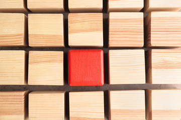 One red cube among wooden ones. Difference and uniqueness concept