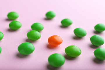 One red drop among green on color background. Difference and uniqueness concept