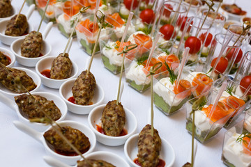 Little glasses with fresh salads stand on white table