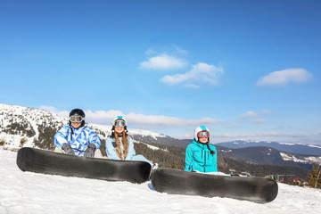 Group of snowboarders on ski piste at snowy resort. Winter vacation