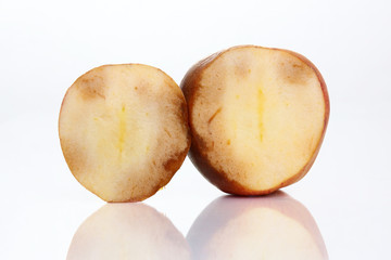 Rotten apple with internal mold on a white background.