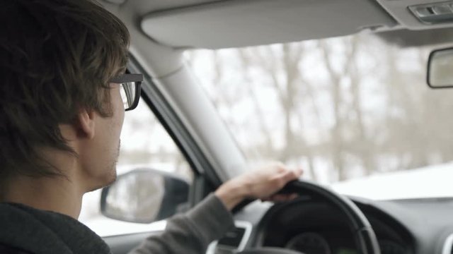 Young man driving a car in winter