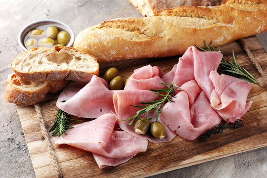 Sliced ham on wooden board. Fresh prosciutto. Pork ham sliced.