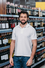 portrait of smiling shop assistant looking at camera in supermarket
