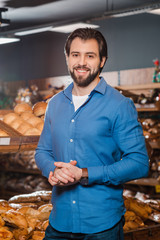 portrait of smiling man looking at camera in supermarket