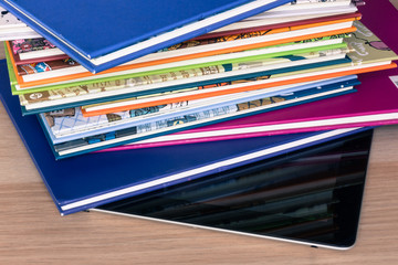 A pile of books lying on shut off tablet