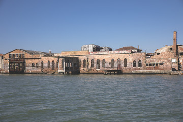 View on an old abandoned glass factory on the island of Murano from the Venice lagoon, Italy