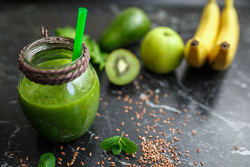 Blended green smoothie with ingredients on table - obrazy, fototapety, plakaty