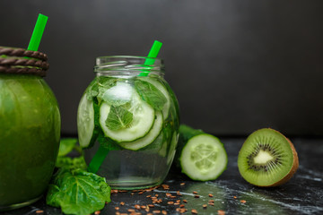 Blended green smoothie and detox with ingredients on table