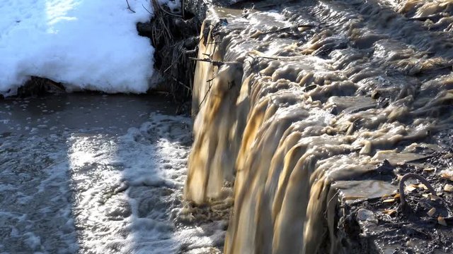 Dirty water pouring waterfall in the spring river. Close up. 4K, 25 fps