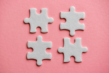 Fototapeta premium four white details of puzzle on pink background