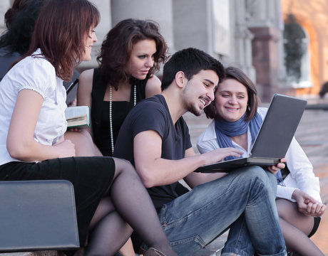 group of fellow students with books and laptop