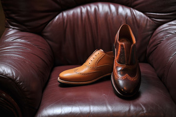 leather handmade shoes on a leather sofa with a dark color