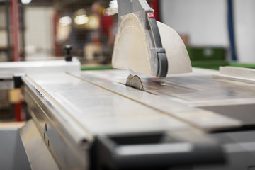 production, manufacture and woodworking industry concept - sliding panel saw at workshop