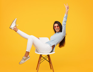 Excited hipster girl posing on chair