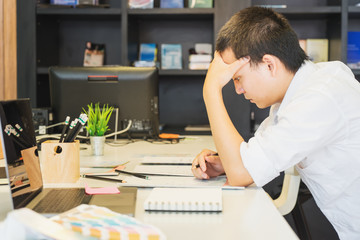 Obraz na płótnie Canvas Stressed male designer sitting at desk in the office