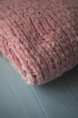Fototapeta na wymiar plush, pink, knitted plaid on the windowsill