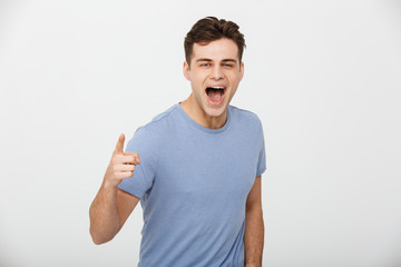 Portrait of an excited young man pointing finger at camera