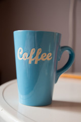 Big, blue coffee cup on white table