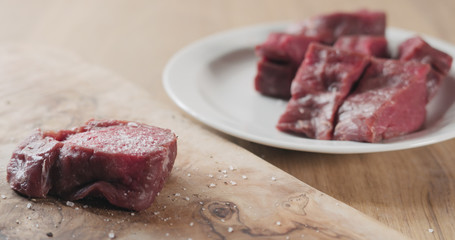 seasoned raw beef fillet for steak on wooden board