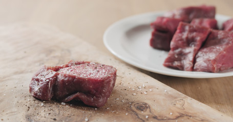 seasoned raw beef fillet for steak on wooden board