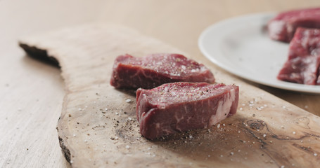 seasoned raw beef fillet for steak on wooden board