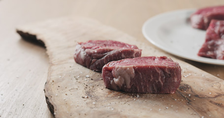 seasoned raw beef fillet for steak on wooden board