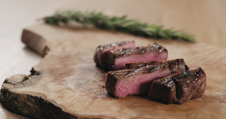 sliced medium fillet mignon steak on wood board