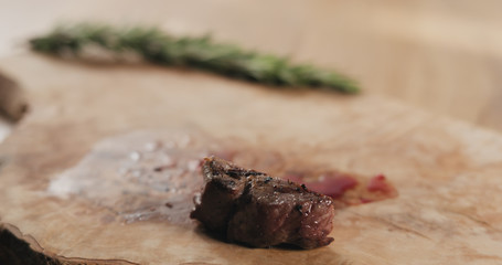 sliced medium fillet mignon steak on wood board