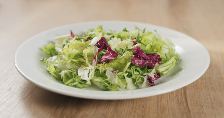 adding olive oil to salad leaves