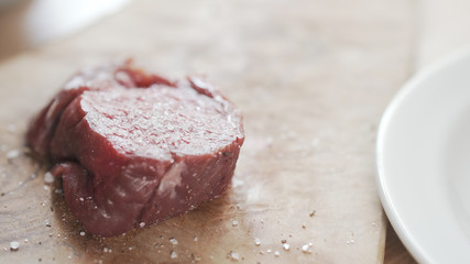 seasoned raw beef fillet for steak on wooden board