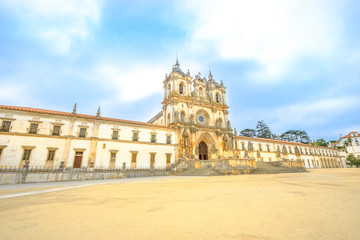Fototapeta na wymiar Perspective view of Roman Gothic Monastery of Alcobaca or Mosteiro de Santa Maria de Alcobaca, UNESCO Heritage, Alcobaca city.The church and abbey were the first Gothic building in Portugal.Copy space
