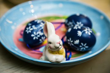 Easter bunny in a colored ceramic plate with eggs