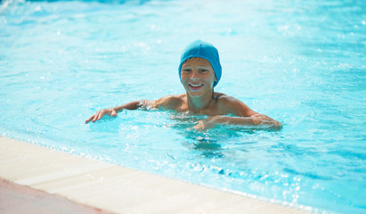 Fototapeta na wymiar Teenager in an outdoor pool with a water slide.